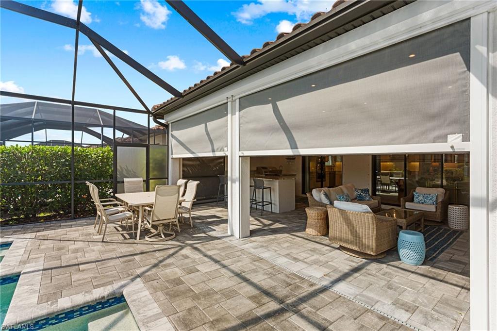 15216 Turin Drive Naples, FL 34114 - Photo 4 of 50 View of patio / terrace with a lanai, an outdoor pool, a sunroom, and an outdoor bar and dining area