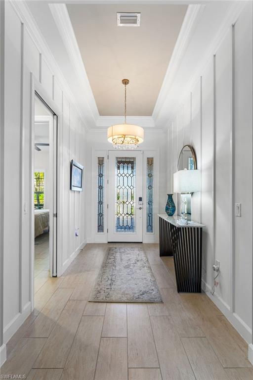 15216 Turin Drive Naples, FL 34114 - Photo 7 of 50 Foyer with a raised ceiling, wood finish floors, and ornamental molding