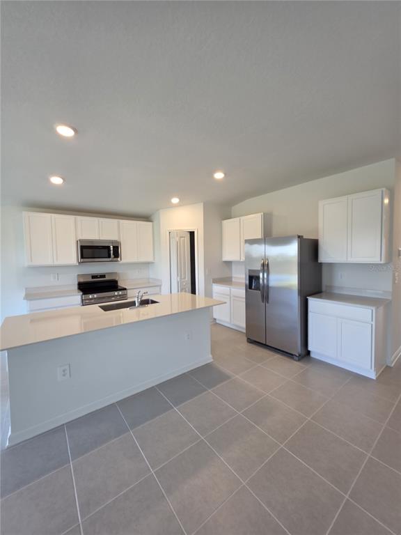 3484 Chinotto Drive Lake Alfred, FL 33850 - Photo 9 of 32 a kitchen with a refrigerator and a stove top oven