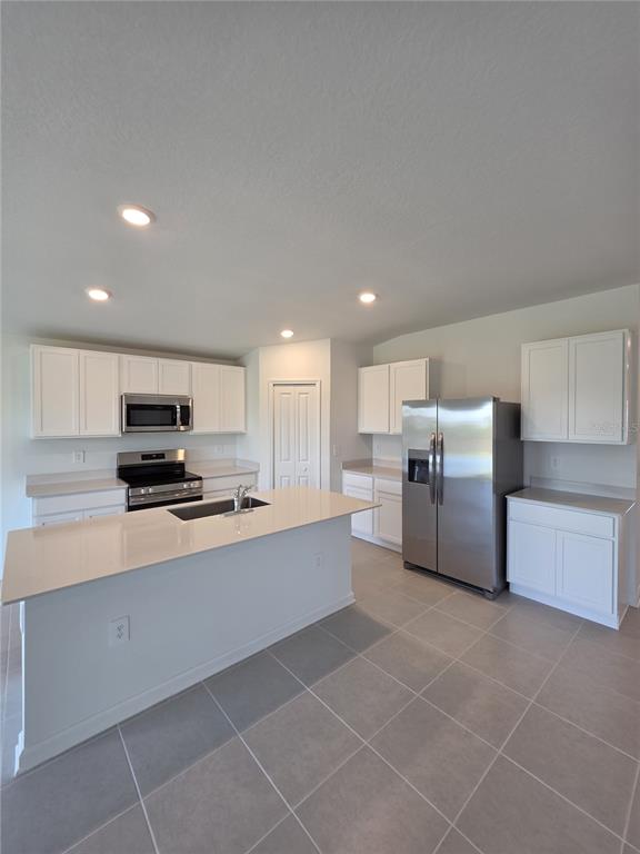 3484 Chinotto Drive Lake Alfred, FL 33850 - Photo 10 of 32 a kitchen with stainless steel appliances a refrigerator sink and stove