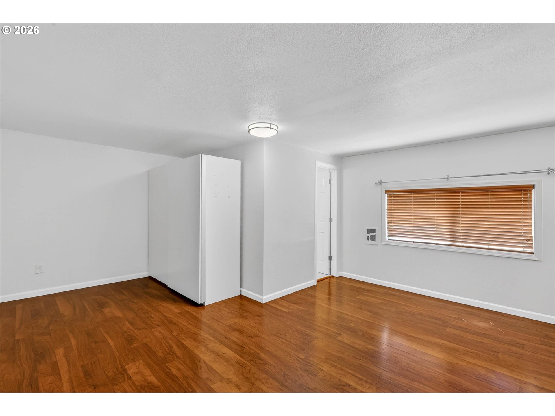 19995 Southwest York Street Beaverton, OR 97003 - Photo 5 of 37 a view of an empty room with wooden floor and a window
