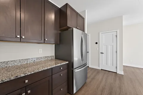 a kitchen with granite countertop stainless steel appliances a refrigerator and cabinets
