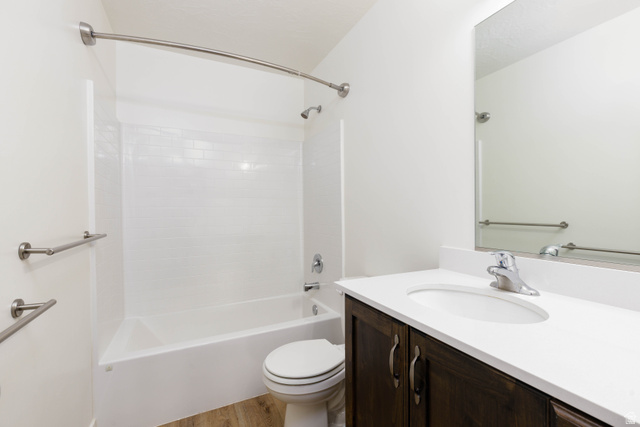 3157 Deseret Drive St. George, UT 84790 - Photo 18 of 24 Bathroom featuring a tub/shower combination with subway tile surround, dark wood-finish vanity with a white countertop, and wood-finish flooring