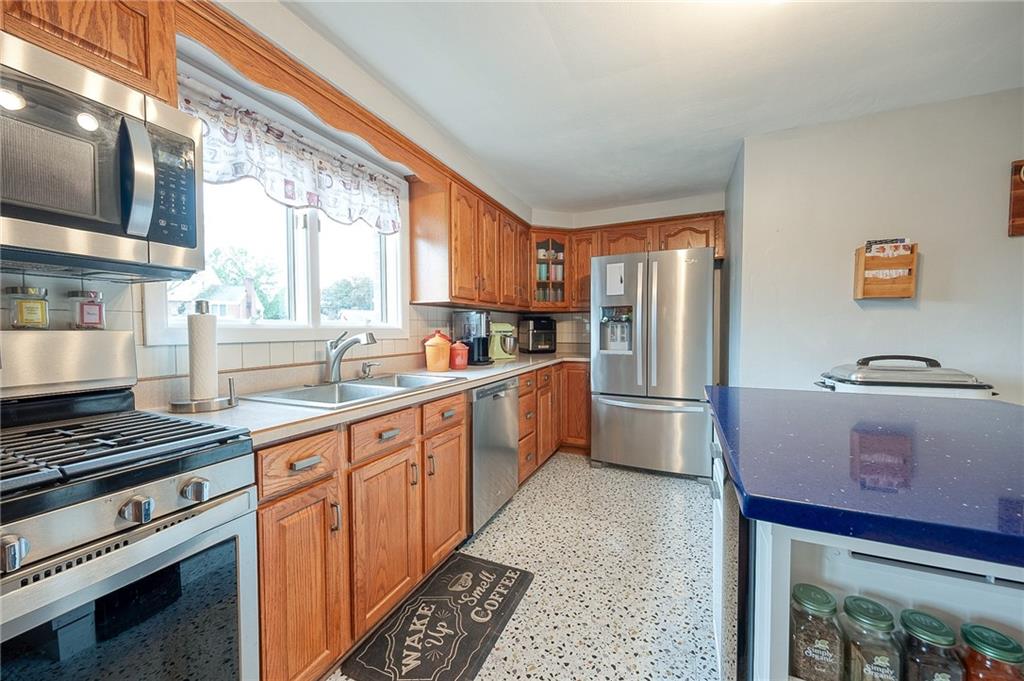 1004 Fiddleback Drive McKees Rocks, PA 15136 - Photo 10 of 41 a kitchen with stainless steel appliances granite countertop a stove a sink and a refrigerator