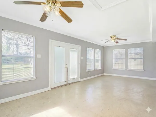 a view of an empty room with window and cabinet