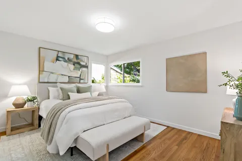 a bedroom with a bed and wooden floor
