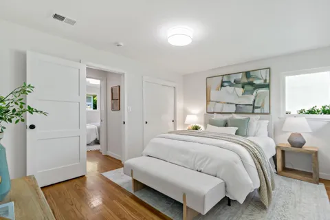 a bedroom with a bed and a potted plant