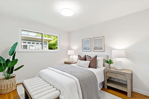 a bedroom with a bed and a potted plant