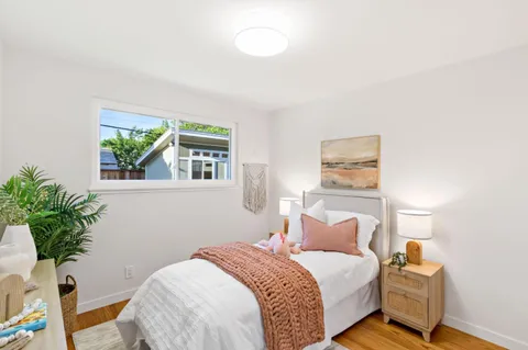 a bedroom with a bed and a potted plant