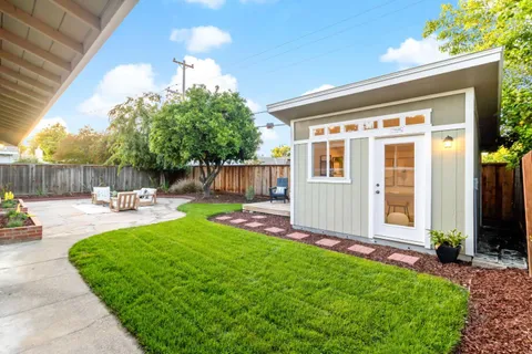 a view of a backyard with table and chairs and wooden fence