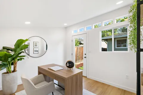 a dining room with furniture and potted plants