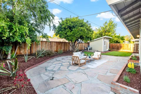 a view of a house with backyard sitting area and garden