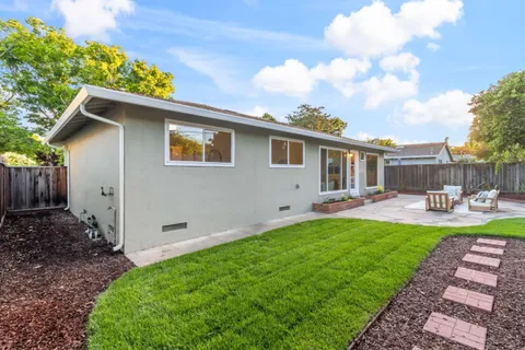 a view of a house with backyard and sitting area