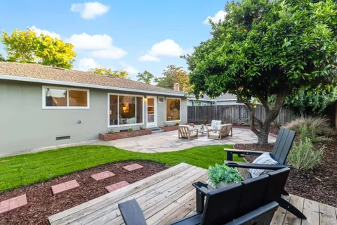 a view of house with backyard and sitting area