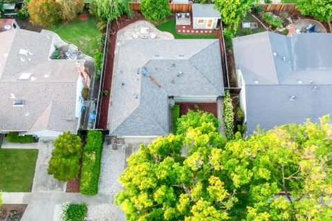 an aerial view of residential houses with outdoor space and trees