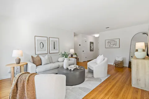 a living room with furniture and wooden floor