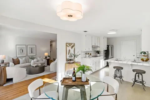 a living room with furniture kitchen and a table