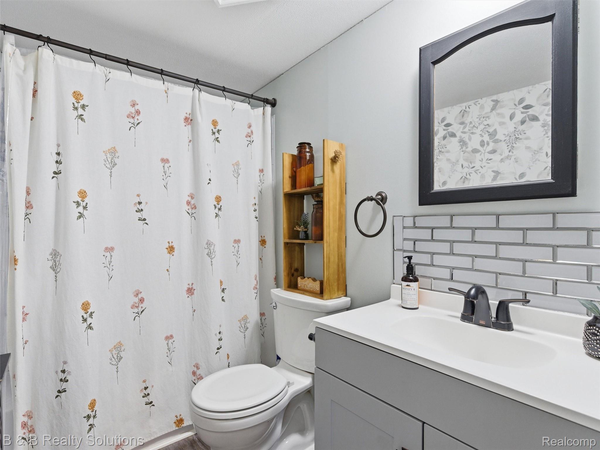 60455 Bates Road New Haven, MI 48048 - Photo 31 of 58 Bathroom featuring a contemporary vanity with a gray cabinet, integrated white sink, and dark-finish faucet