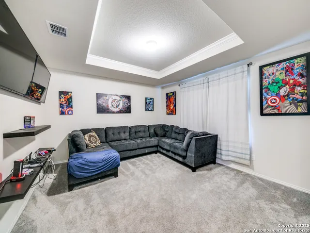 a living room with furniture a flat screen tv and gym equipment