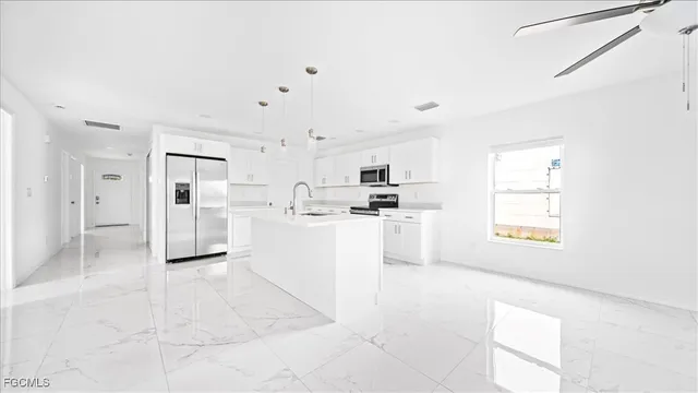 a kitchen with white cabinets and refrigerator