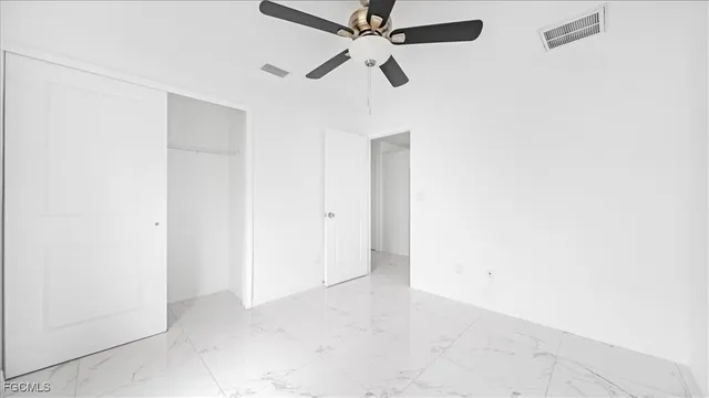 an empty room with a ceiling fan and a window