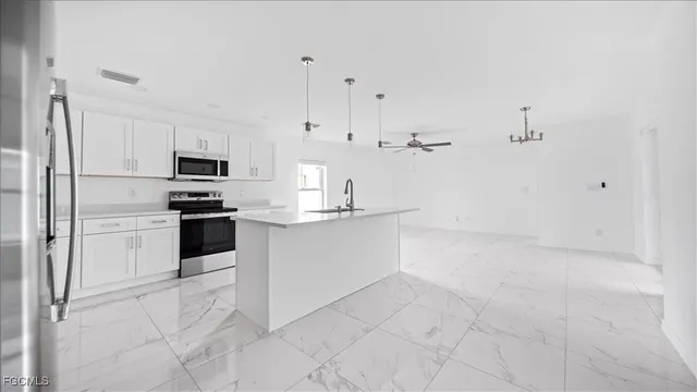a kitchen with white cabinets and stainless steel appliances