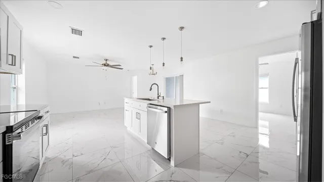 a kitchen with stainless steel appliances granite countertop a sink a stove and a refrigerator