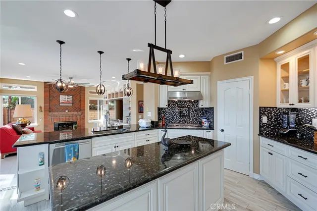 a bathroom with a granite countertop sink and a large mirror
