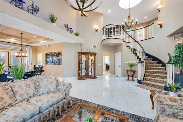 a dining room with wooden floor a chandelier a wooden table and chairs