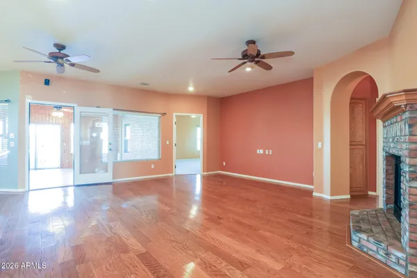a view of an empty room with window and wooden floor