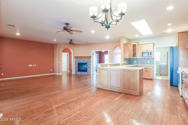 a open kitchen with a sink dishwasher a stove and a refrigerator with wooden floor