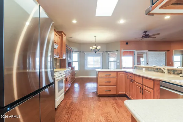 a large kitchen with granite countertop a large counter top appliances and cabinets
