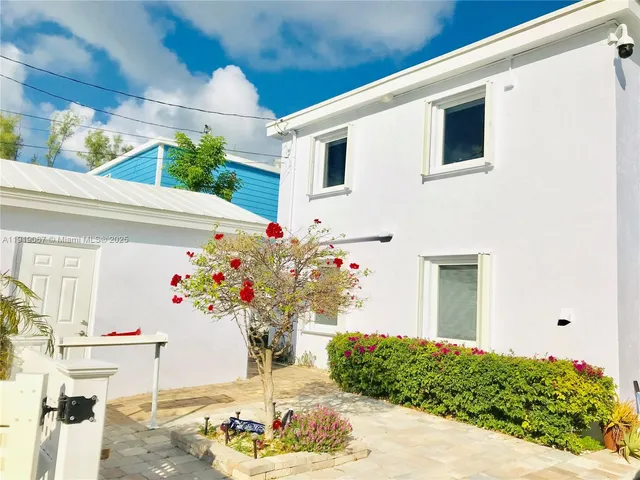a vase of flowers sitting on a floor in front of a door