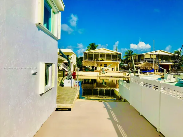 a view of a patio with chairs and umbrellas