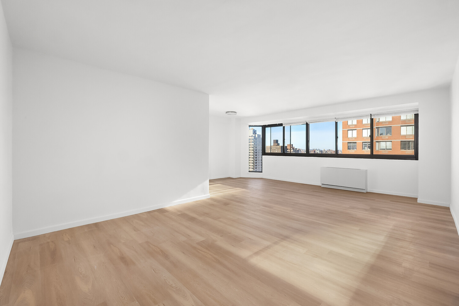 1725 York Avenue, Unit 31H Manhattan, NY 10128 - Photo 3 of 11 wooden floor in an empty room with a window