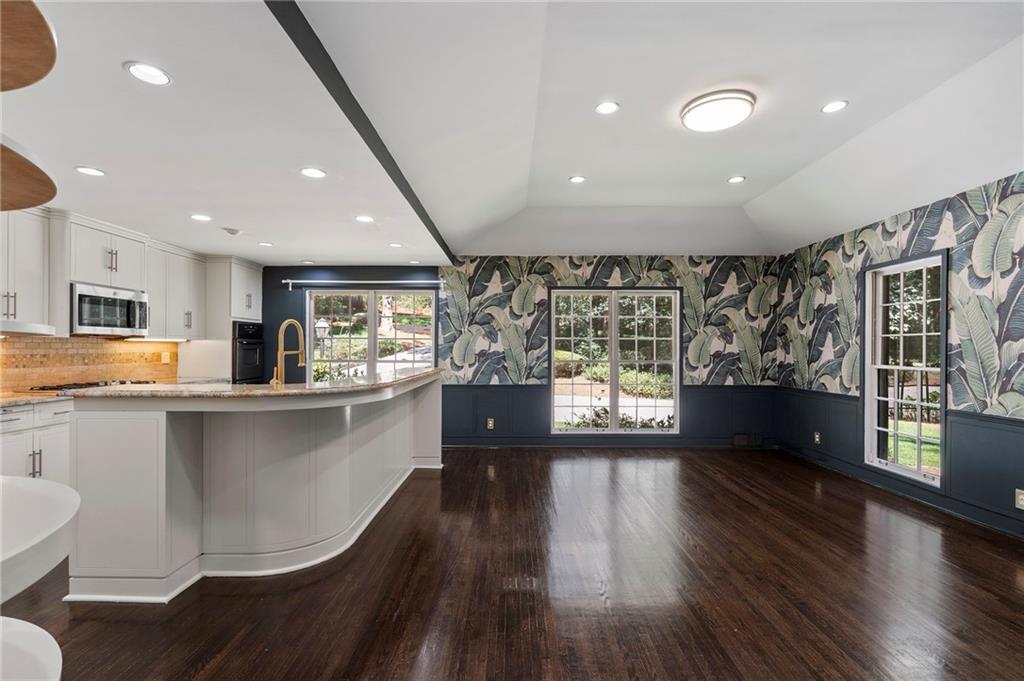 1190 West Wesley Road Northwest Atlanta, GA 30327 - Photo 15 of 46 a kitchen with stainless steel appliances a large counter top a stove a sink a refrigerator with wooden cabinets and wooden floor