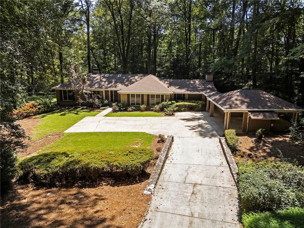 1190 West Wesley Road Northwest Atlanta, GA 30327 - Photo 2 of 46 a view of a swimming pool with lawn chairs under an umbrella