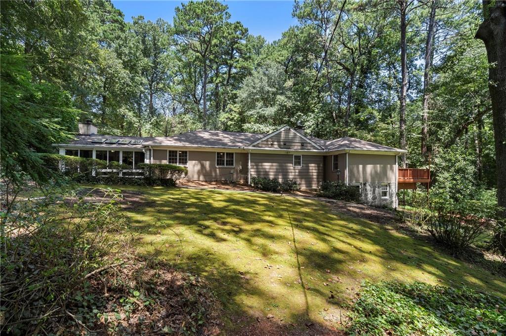 1190 West Wesley Road Northwest Atlanta, GA 30327 - Photo 38 of 46 a front view of a house with a yard table and chairs under an umbrella