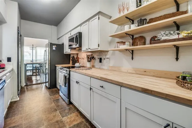 a kitchen with kitchen island a sink stainless steel appliances and cabinets