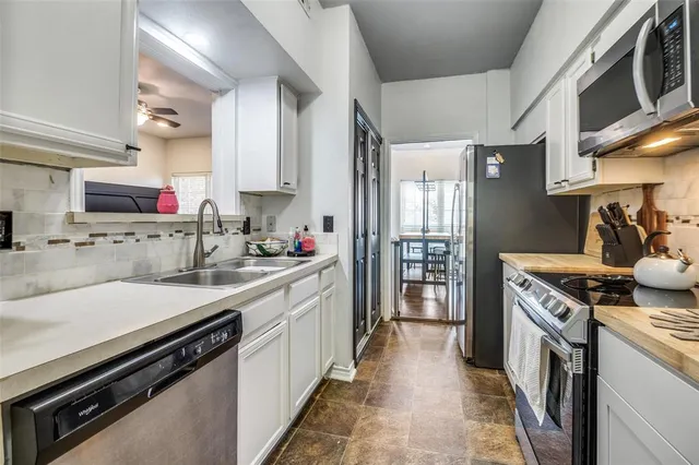 a kitchen with a sink stove top oven and cabinets