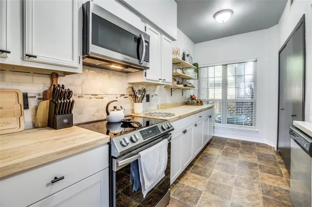 a kitchen with stainless steel appliances granite countertop a stove a sink and a microwave