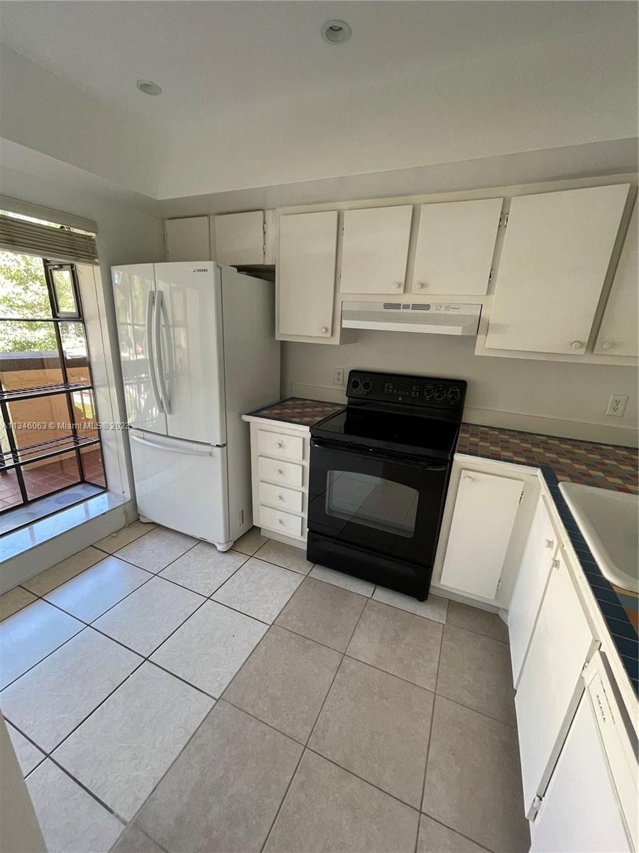 2201 Southwest 15th Street, Unit 252 Deerfield Beach, FL 33442 - Photo 2 of 12 a kitchen with a refrigerator and a stove top oven