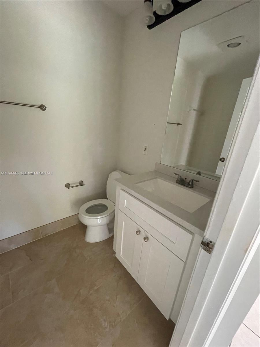 2201 Southwest 15th Street, Unit 252 Deerfield Beach, FL 33442 - Photo 4 of 12 a bathroom with a granite countertop sink a toilet and a mirror