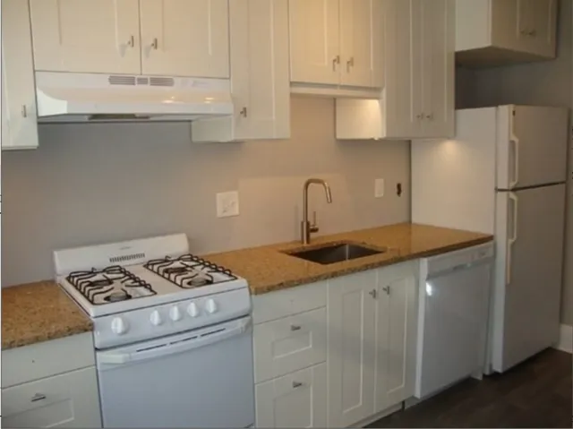a kitchen with appliances a sink and cabinets