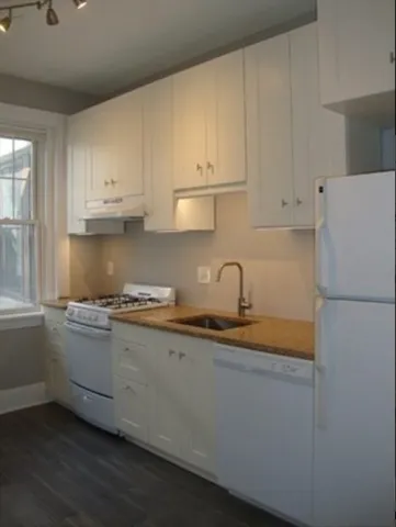 a kitchen with granite countertop a sink and a stove top oven