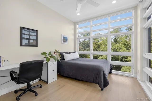 a bedroom with a bed and a large window