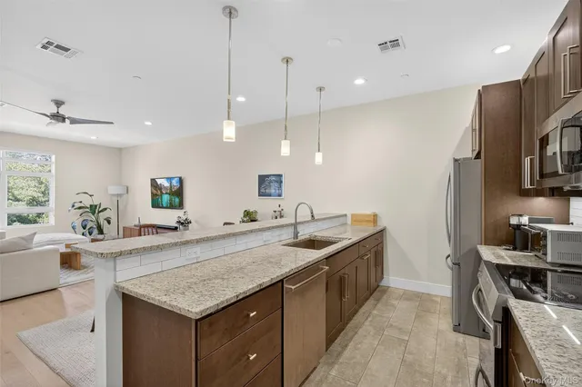 a kitchen with granite countertop a sink a counter top space appliances and cabinets