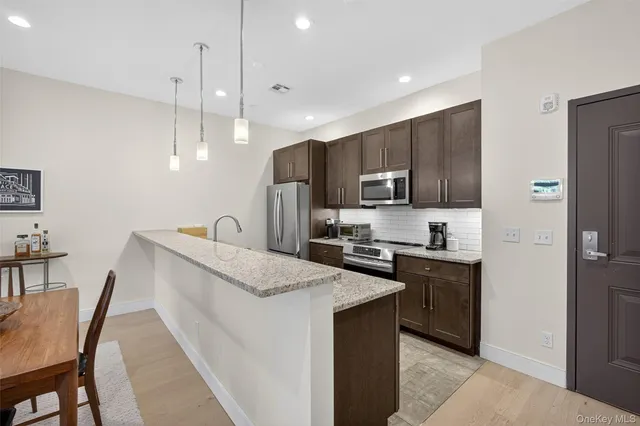 a kitchen with kitchen island granite countertop a stove sink microwave and refrigerator