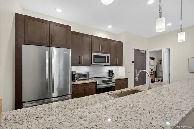 a kitchen with stainless steel appliances granite countertop a refrigerator stove and oven