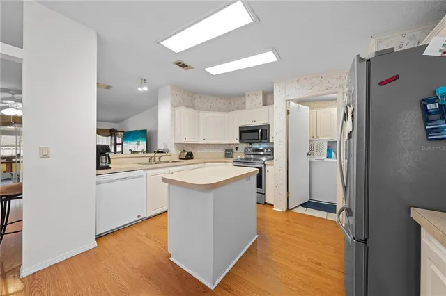a kitchen with stainless steel appliances a refrigerator and a stove top oven